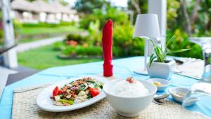 a plate of food with rice and a red candle at Kelimutu Crater Lakes Ecolodge in Kelimutu