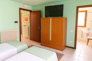 a bedroom with a bed and a television on a cabinet at Affittacamere Al Fiume in Flambruzzo