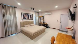a bedroom with a bed and a flat screen tv at NICHA Cafe' & Resort in Ban Thap Chek Ha +9 photos