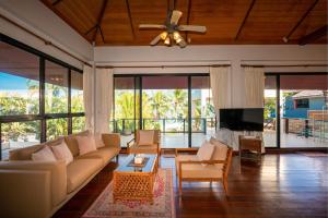 a living room with a couch and a tv at Baan SanSuk Pranburi - Beach Front & Pool Villa in Pran Buri