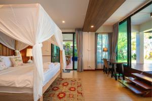 a bedroom with a bed with a white canopy at Baan SanSuk Pranburi - Beach Front & Pool Villa in Pran Buri +70 photos