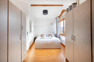 a bedroom with a white bed and a window at Le Chalet Panoramique Jaccuzi Parking Vue Montagne in Munster