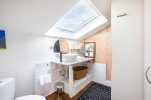 a bathroom with a sink and a skylight at Le Chalet Panoramique Jaccuzi Parking Vue Montagne in Munster +36 photos
