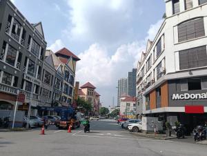 a city street with buildings and a person riding a motorcycle at Q Inn by Pillow Plus in Petaling Jaya