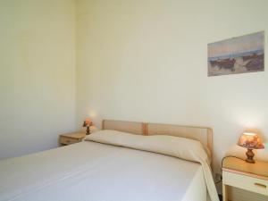 a bedroom with a white bed and two night stands at Residence Villaggio Smedile in Capo Vaticano