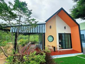 a small house with an orange and white facade at NICHA Cafe' & Resort in Ban Thap Chek Ha