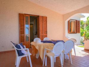 a table with white chairs and a blue table cloth at Residence Villaggio Smedile in Capo Vaticano