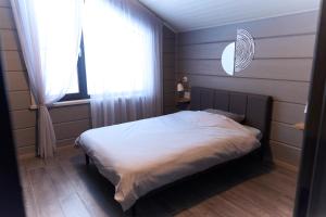 a bedroom with a white bed and a window at MATRYOSHKA HOUSE 2nd GUEST HOUSE in Yoichi