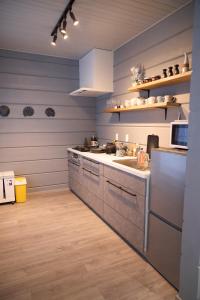 a kitchen with blue walls and white cabinets and a sink at MATRYOSHKA HOUSE 2nd GUEST HOUSE in Yoichi
