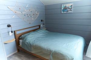 a bedroom with blue walls and a bed with a net at MATRYOSHKA HOUSE 2nd GUEST HOUSE in Yoichi