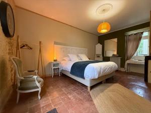 a bedroom with a bed and a chair at Studio Charmant au Château Leugny in La Celle-sous-Gouzon