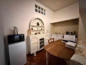 a kitchen with a wooden table and a microwave at Studio Charmant au Château Leugny in La Celle-sous-Gouzon
