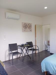 a room with a table and chairs and a bed at Studio CARAIBE in Saint-François +5 photos