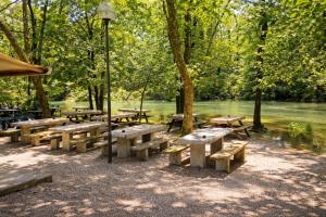 a group of picnic tables in a park next to a river at Affittacamere Al Fiume in Flambruzzo