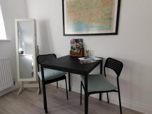 a black table with two chairs and a map on the wall at Petralia BnB in Portland +8 photos