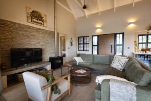 a living room with a couch and a tv at Villa Kolobe in Hoedspruit