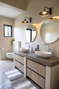 a bathroom with two sinks and a large mirror at Villa Kolobe in Hoedspruit +38 photos