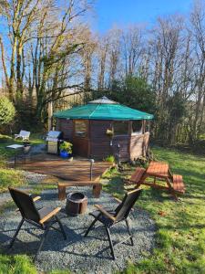 a cabin with chairs and a table and an umbrella at Galtee Glamping in wooden yurt in Mitchelstown