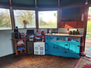 a kitchen with blue cabinets and a sink and windows at Galtee Glamping in wooden yurt in Mitchelstown