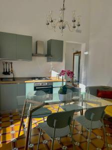 a kitchen with a glass table and chairs at Palazzo '800 Cementine in Leverano