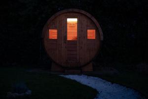 a wooden cabin with a door in the dark at Burbujas de amor - gîte avec spa et sauna privatifs in Loubès-Bernac