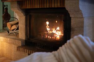 a person sitting in front of a fireplace at Burbujas de amor - gîte avec spa et sauna privatifs in Loubès-Bernac +38 photos