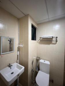 a bathroom with a white toilet and a sink at Skyhaus Homestay in Penampang