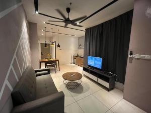 a living room with a couch and a flat screen tv at Skyhaus Homestay in Penampang