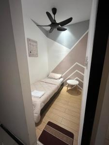 a small room with a bed and a ceiling fan at Skyhaus Homestay in Penampang