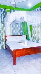 a bedroom with a bed with a canopy and curtains at Tum Hotel & Conferencing in Mombasa +22 photos