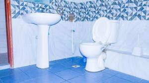 a bathroom with a white toilet and a sink at Tum Hotel & Conferencing in Mombasa