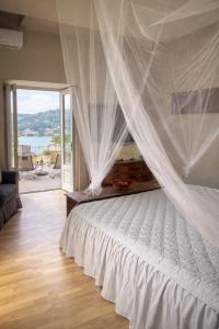 a bedroom with a bed with a white canopy at Villa Miranda Luxury Como Lake View Penthouse with Panoramic Terrace in Como