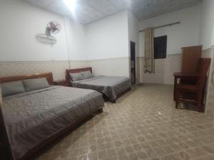 a room with two beds and a table in it at Homestay Mỹ Ánh 1 in Phú Quốc