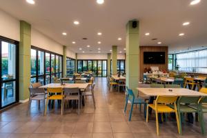 a dining room with tables and chairs and windows at Belvedere Village in Castelnuovo del Garda