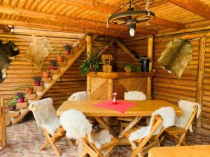 a wooden dining room with a wooden table and chairs at Casa Andu in Dâmbovicioara