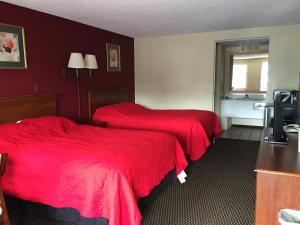 2 camas en una habitación de hotel con sábanas rojas en FairBridge Inn Express Merrillville en Merrillville