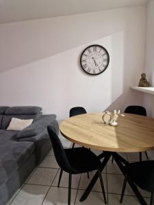 a dining room with a table and a clock on the wall at Viktoria Apartment in Speicher