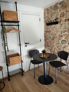 a table and chairs in a room with a stone wall at Ca l'Eli Loft in Montblanc +20 photos