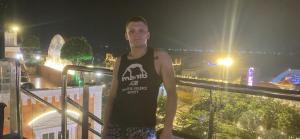 a man standing on a balcony at night at Homestay Mỹ Ánh 1 in Phú Quốc