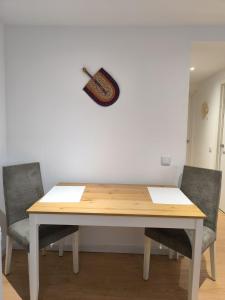 a table with two chairs and a guitar on the wall at Casa do Bento - Charming Cozy Loft, Vila do Conde in Fajozes