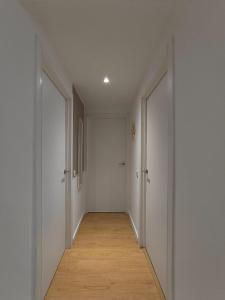 an empty hallway with white walls and a wooden floor at Casa do Bento - Charming Cozy Loft, Vila do Conde in Fajozes