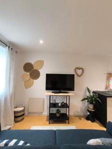 a living room with a blue couch and a flat screen tv at Casa do Bento - Charming Cozy Loft, Vila do Conde in Fajozes