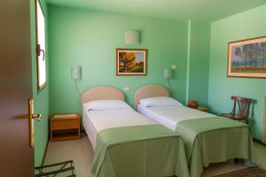 two beds in a room with green walls at Affittacamere Al Fiume in Flambruzzo