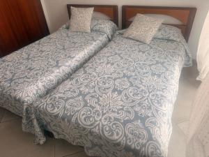 a bedroom with two beds with a blanket and pillows at Habitación Doble a 100 m de la Playa in Benidorm
