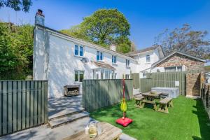 a backyard with a wooden fence and a table and a grill at 2 Bed in Bush oc-s31846 in Bude