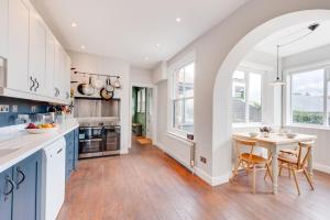 a kitchen with white cabinets and a table with chairs at 5 Bed in Walberswick oc-tww in Walberswick