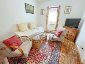 a living room with a couch and two chairs and a tv at Tre Terre in Mulazzo