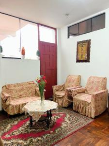 a living room with a couch and two chairs and a table at Hostal Violeta in Arequipa