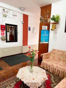 a living room with a vase of flowers on a table at Hostal Violeta in Arequipa +22 photos