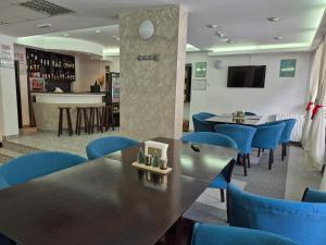 a restaurant with blue chairs and tables and a bar at Cristal Sinaia in Sinaia